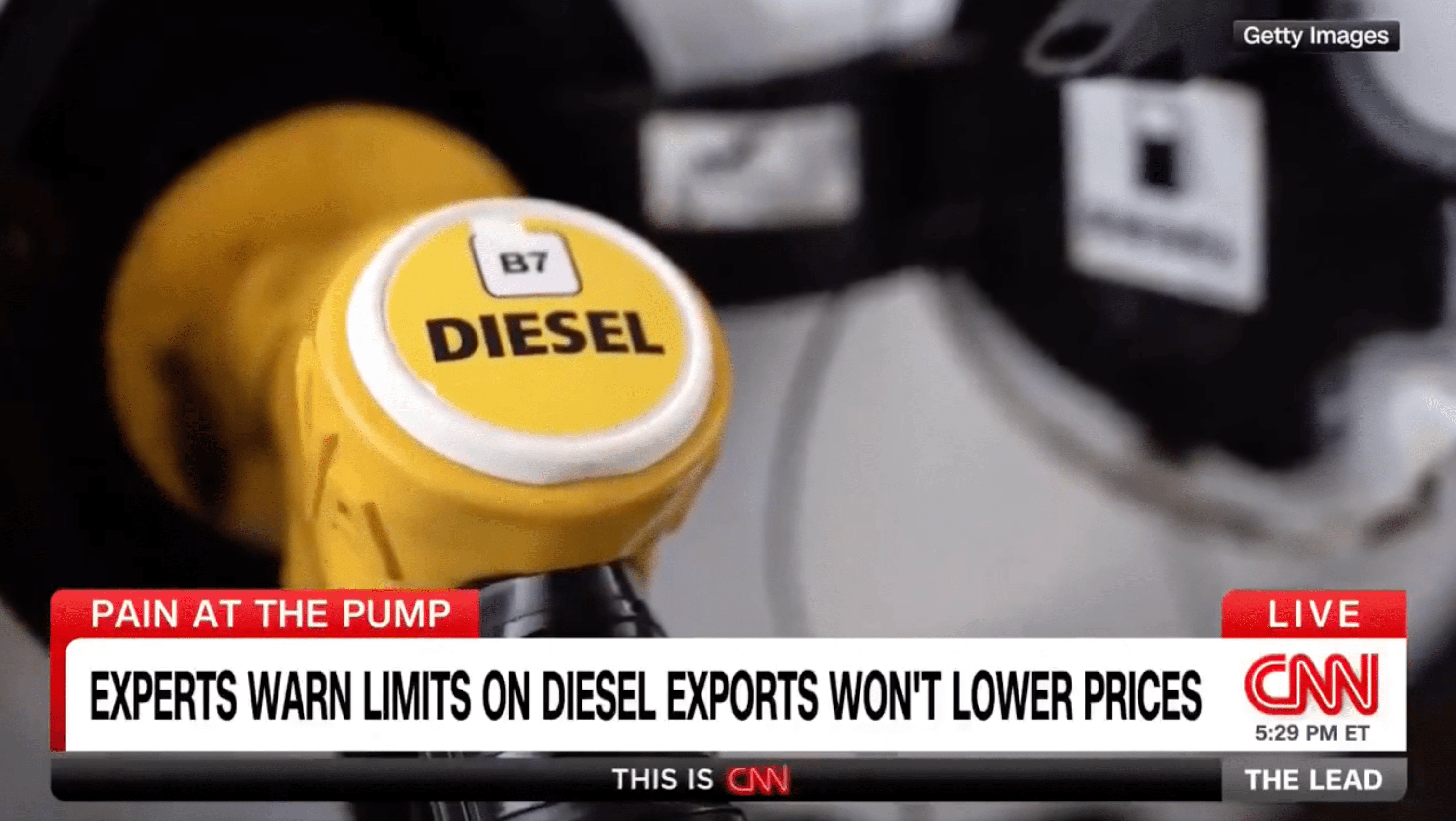 Close-up of a yellow diesel fuel pump nozzle shown during a CNN news segment about diesel export limits and fuel prices.